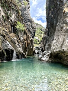 Stunning waterfall and turquoise pool in a rocky Antalya canyon landscape.